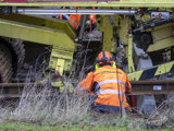  Bild på en orangeklädd järnvägstekniker som inspekterar en spårbytesmaskin